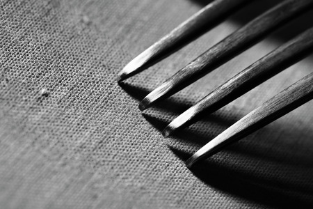 Fork on rough fabric textured background macroの写真素材