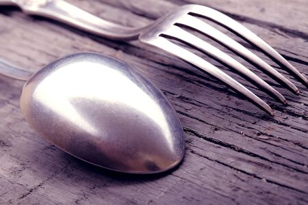 Spoon and fork on a worn wooden backgroundの写真素材