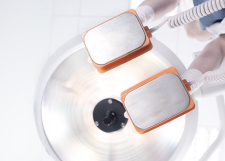 Doctor ready for cardioversion with electrodes in handsの写真素材