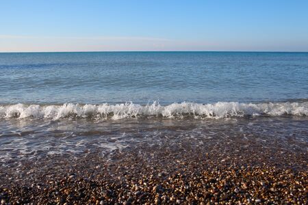 Surf on the shore of pebblesの写真素材
