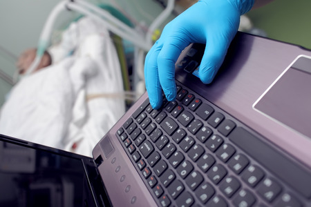 Hospital management concept, doctor's hand working on a computer in the background of the patientの写真素材