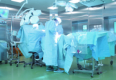 Surgeons team operating, defocused background.