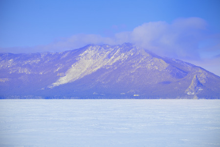 Winter mountain landscape at the lake covered with iceの写真素材