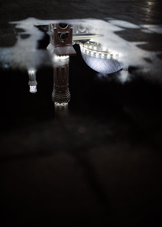 Mosque reflected in puddle water.
