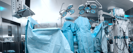 Panoramic image of the modern operating room with the personnel working with the patient.の写真素材