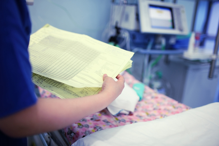 Female doctor looking to the baby patient medical card.の写真素材