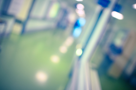 Long blurred hallway lit by ceiling lamps, unfocused background.の写真素材