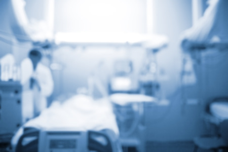 Male doctor figure next to the patient bed in the intensive care unit, unfocused background.の写真素材