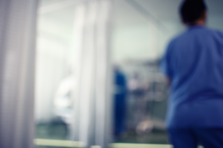 Unfocused background with figures of working medical personnel in the ER.の写真素材