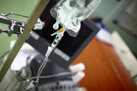 View of doctor's office with equipment and iv drip bag on the steel pole.の写真素材