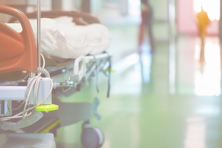Modern medical bed in the hospital hall on the background of walking people.の写真素材