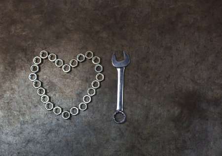 The nut heart with combination wrench on the metal background. The nut heart for valentines day.の写真素材