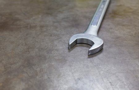 Combination wrench on the metal background