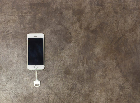 key and mobile phone on the metal background