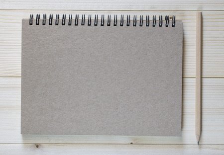 paper notebook and pencil on wooden backgroundの写真素材