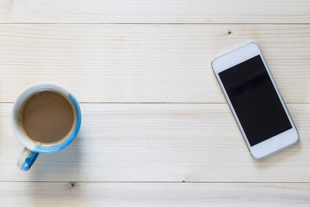 Smart phone and cup of  coffee on wooden background.の写真素材