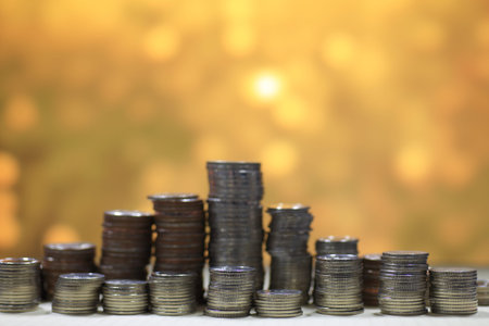 pyramid coin column stacking high, on gold light background. Saving and financial step to success...