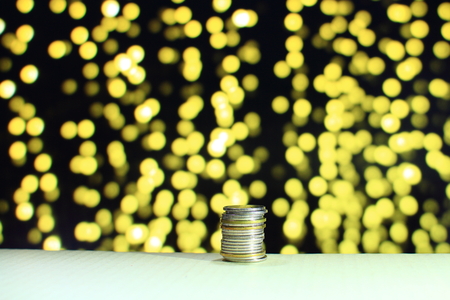 single column coin stack on yellow out of focus light background. For business saving and money related concept.の写真素材