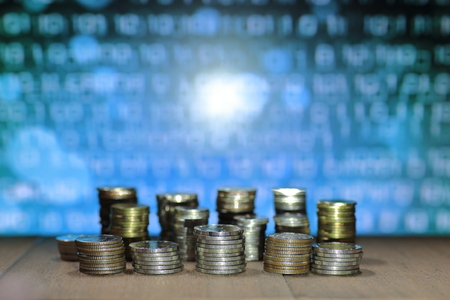 Digital economy. Coin stack with blue binary digital numbers background. Business, finance and saving concept.の写真素材