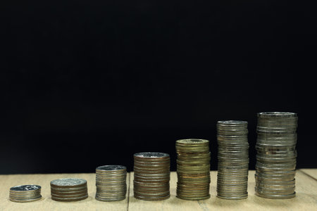 coin pile on wood board isolated on black background