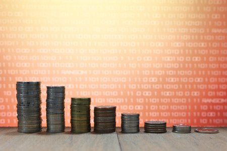 vintage digital economy coin pile stacked in to columns on wooden board. Digital binary code in the...