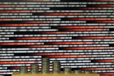 digital economic recession. coin column lined like a declining chart with black and red colour...