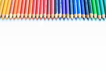 colored pencils rainbow colors row lined on upper side with copy space. creative and kid concepts. old and used color group systematical.の写真素材