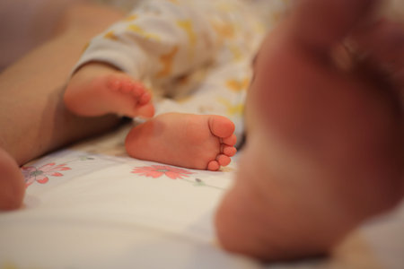 brushing baby teeth. baby struggling agonizingly between mother's legs while being tend to. baby...