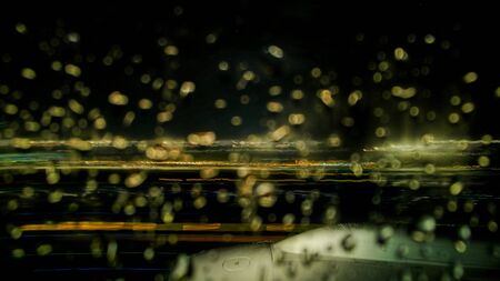 airplane wing motion blur from long exposure night shot during takeoff. long exposure light trails from city light with black sky copy space.の写真素材