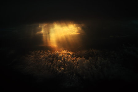 Dramatic god light rays shining from dark cloud on to clouds expanse on the sky. power of hope and...