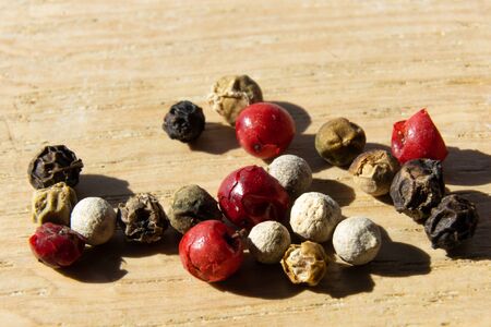 closeup of white, red and black peppercorn on a tableの写真素材