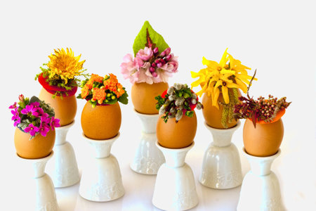 Spring flowers decorate speckled brown chicken eggs with Easter hatsの写真素材