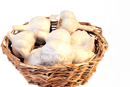 Crisp pink and pearl garlics fill a kitchen basket and are ready to use in cookingの写真素材