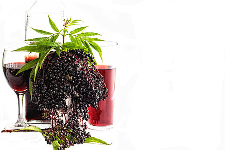 A Bottle of Elder Berry wine, a glass of liquor and one of cordial and water, with the fruit in the centreの写真素材