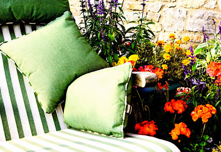 Sun Lounger with Striped Cushions With Pots of Flowers Nearbyの写真素材