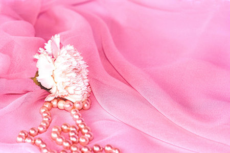 White Carnation Flower and Pearls in Folds of Pink Silk Chiffonの写真素材
