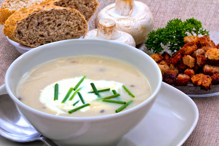 Creamy and Mushroom Soup Decorated with Chives alongside Croutons and Fresh Brown Bread,の写真素材