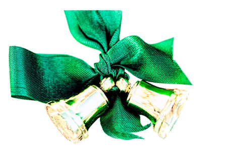 Closeup of a Green Ribbon Bow Tied to Two Small Golden Bellsの写真素材