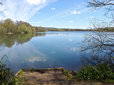 Lake with clouds reflected, jetty and trees.の写真素材