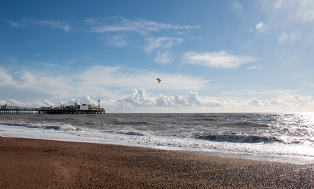 Brighton Pier on the Sussex coast, England, with sunshine, sea and clouds の写真素材