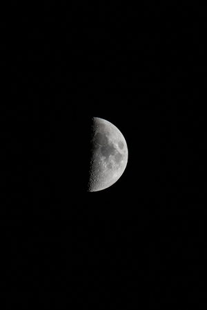 Waxing Moon,portrait orientated image with Moon isolated on black background with text or copy space.の写真素材