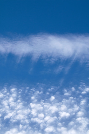 Streaky and puffy Cirrocumulus Clouds against blue sky. Portrait orientation.の写真素材