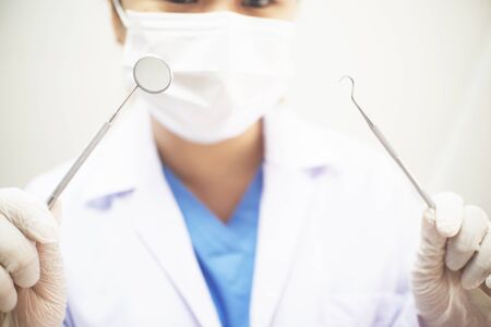 Female Dentist working in office with hands holding toolsの写真素材