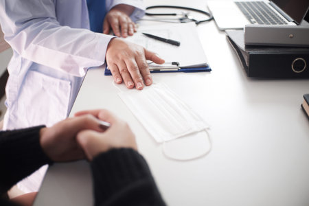 Female medicine doctor working on table with consulting patient.の写真素材