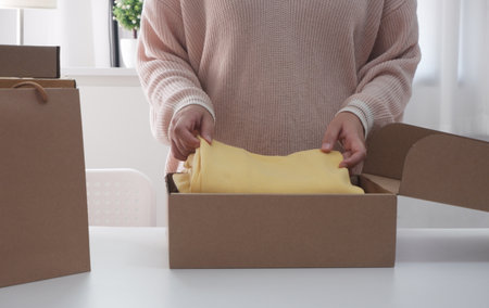 Women packing Cardboard Parcel Box for Online Selling. Woman Seller Prepares the Delivery Box. Packing for Delivery Mail Shipping. E-commerce Startup Small Businessの写真素材