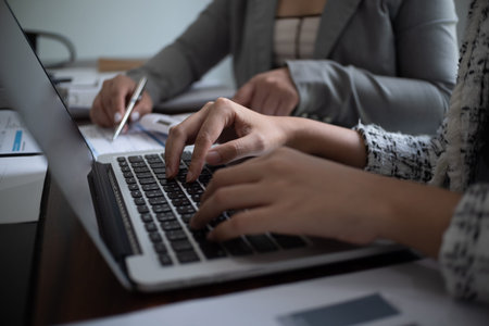 Businesswoman, entrepreneur, accountant working on financial report on desk using calculator,...