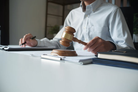 Legal justice man working on desk reading supportive documents to determine the caseの写真素材