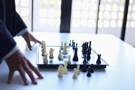 Businessman wearing suit, playing chess, game of strategy, leadership and management concept.の写真素材