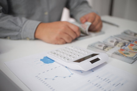 Unrecognizable businessman, accountant, banker working, counting money at the workplaceの写真素材