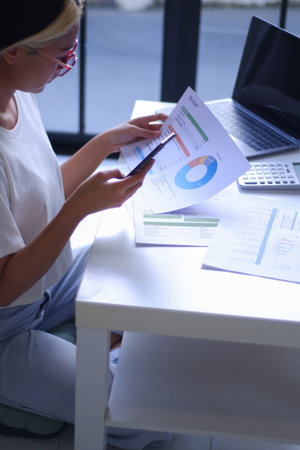 Young Asian women remote work from home analyzing data, calculating, studying.の写真素材
